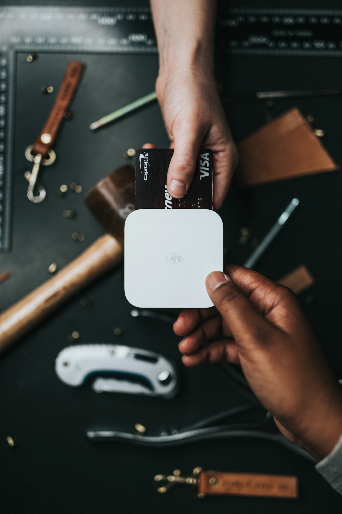 Person handing a Visa credit card over a Square reader