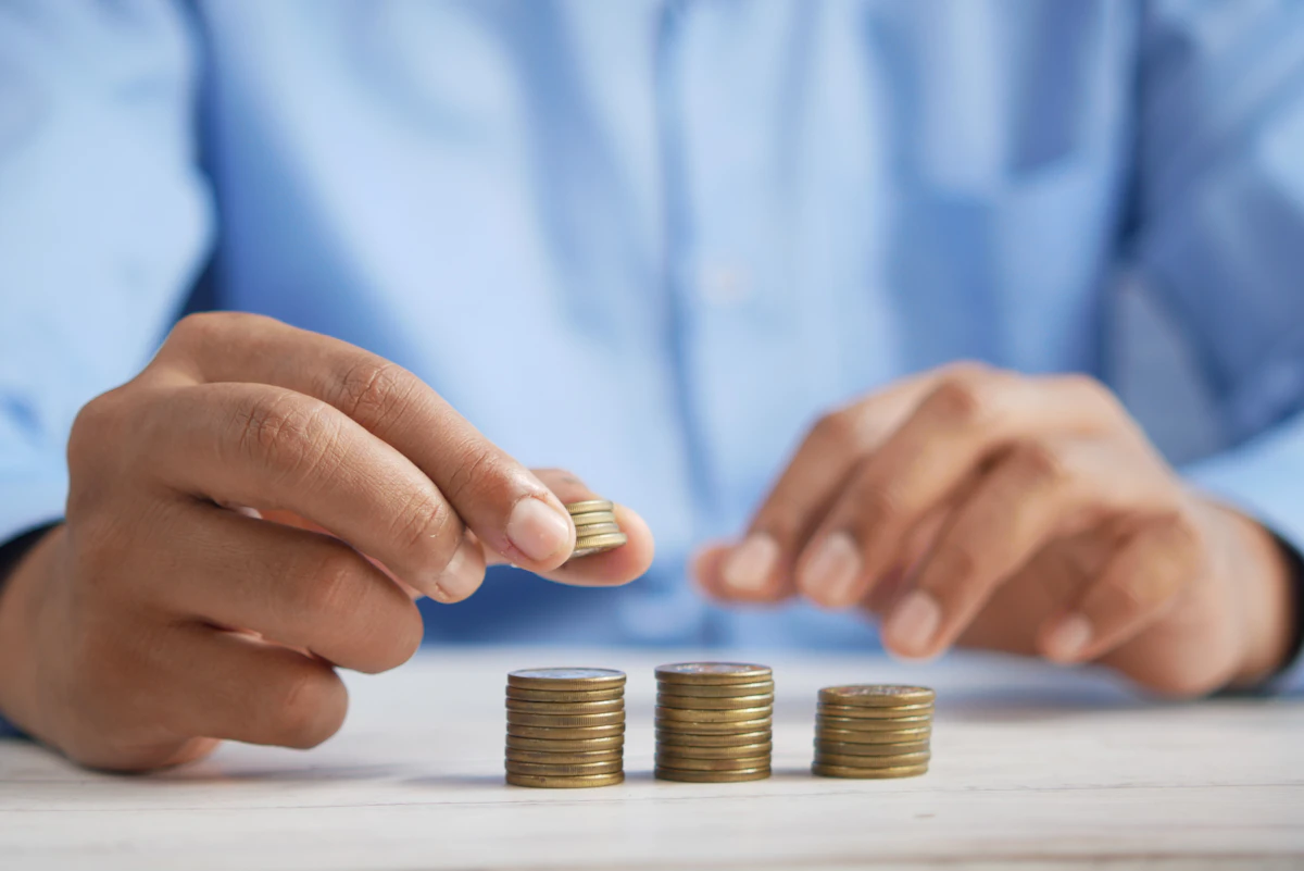 Person stacking coins representing variable income savings
