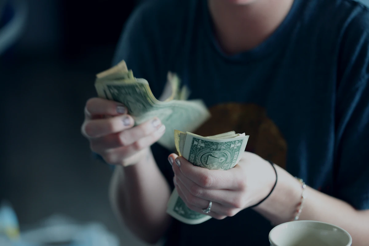 Person carefully counting dollar banknotes