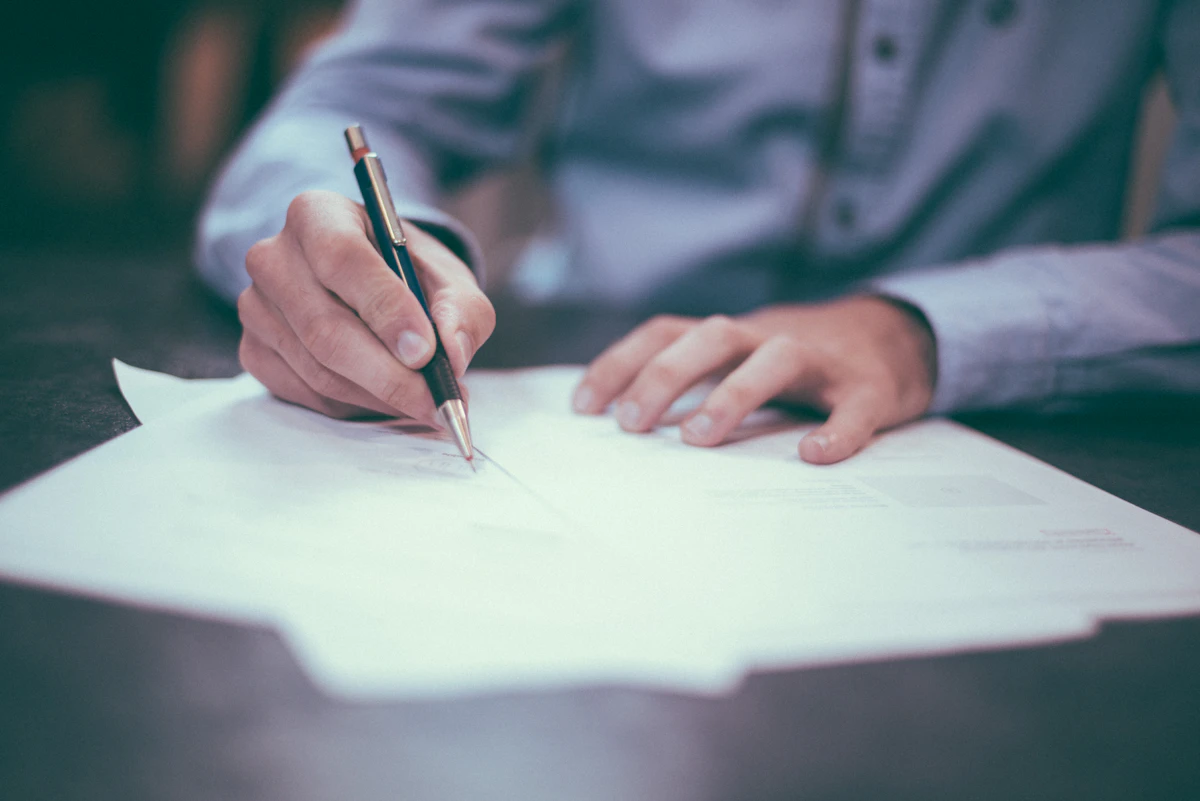 Person signing mortgage documents at a desk