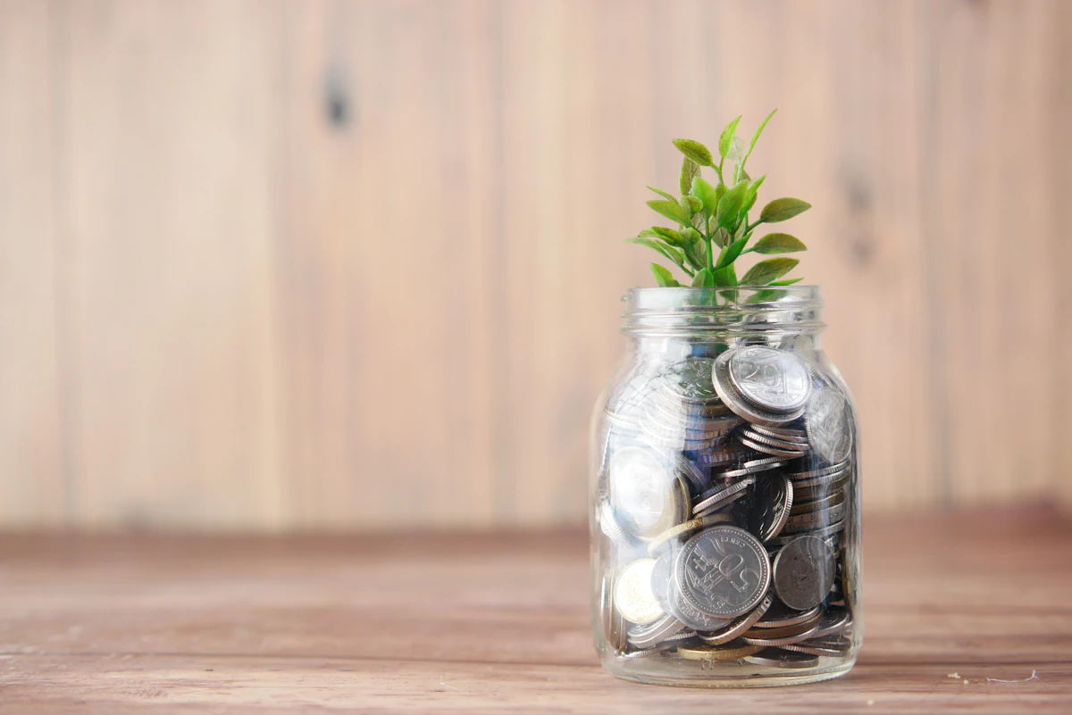Glass jar filled with coins next to a plant