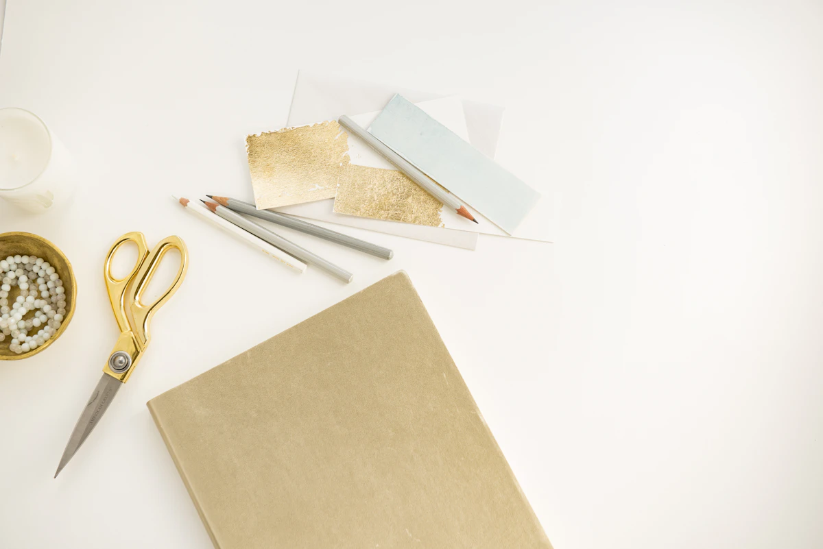 Gold scissors on a white desk representing cutting subscriptions