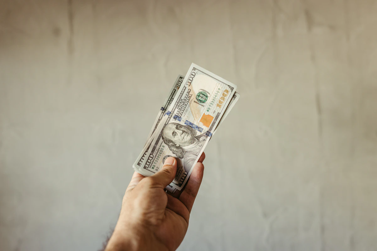 Person holding cash bills representing the envelope budgeting method