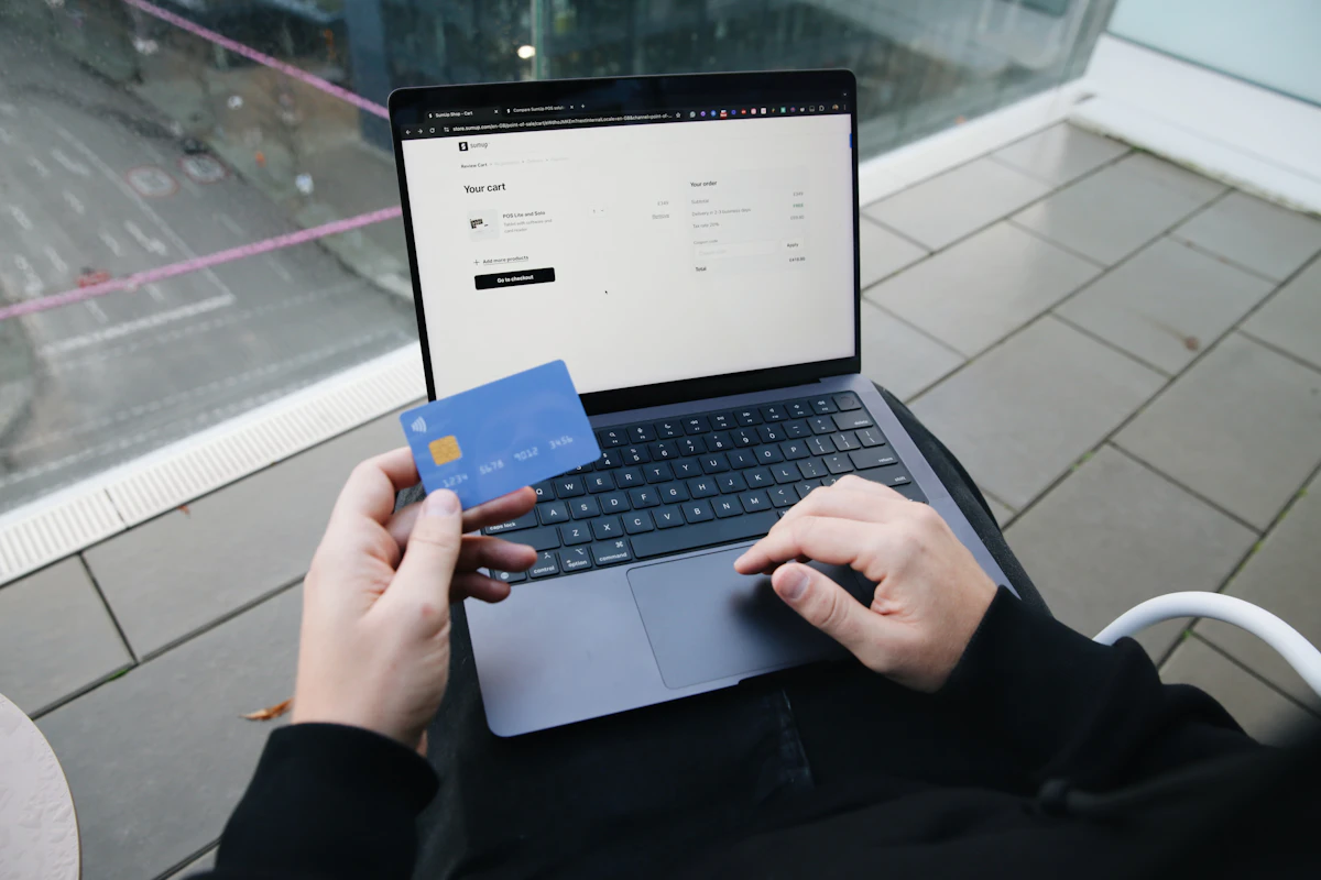 Person sitting in chair with laptop finalizing an online credit card payment